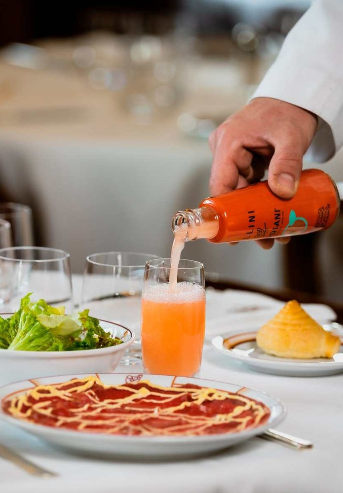 alcohol-free Bellini Cipriani being poured into a cup on a set table